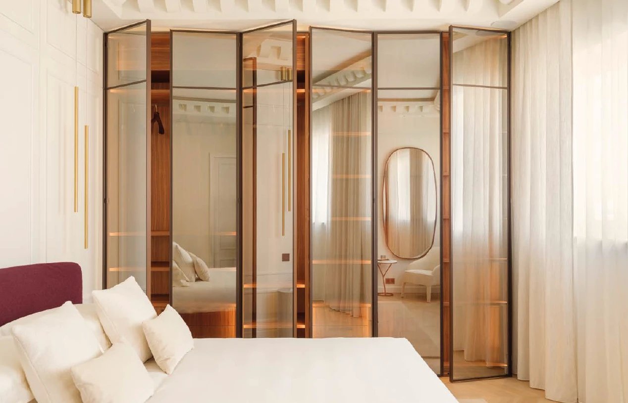 Bronze-framed glass wardrobe doors in a bedroom
