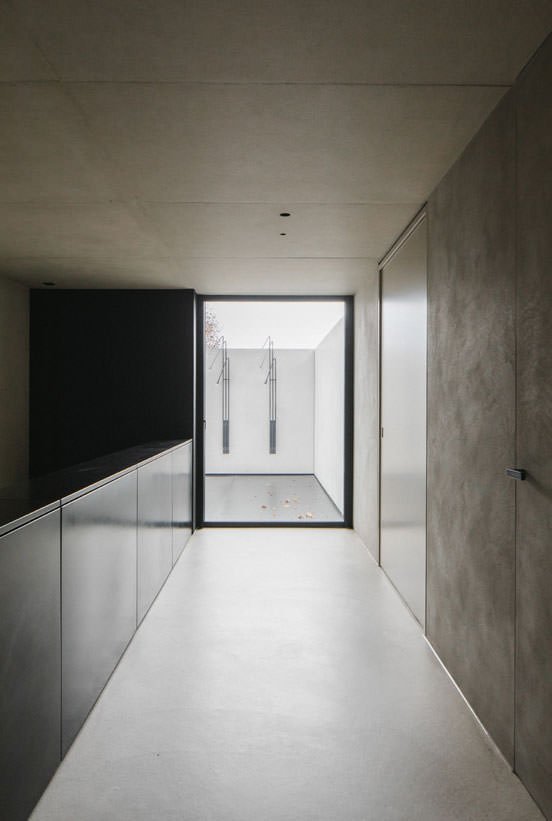 Concrete hallway ending in a floor-to-ceiling glass window