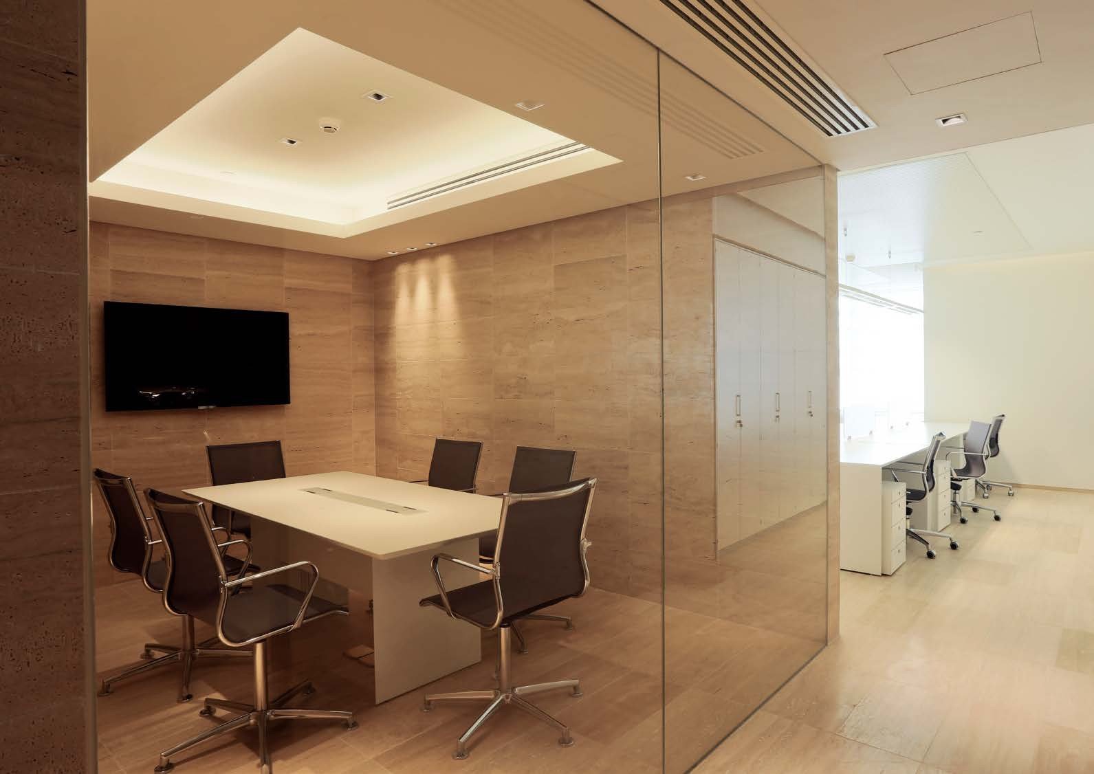Glass-walled meeting room with travertine walls