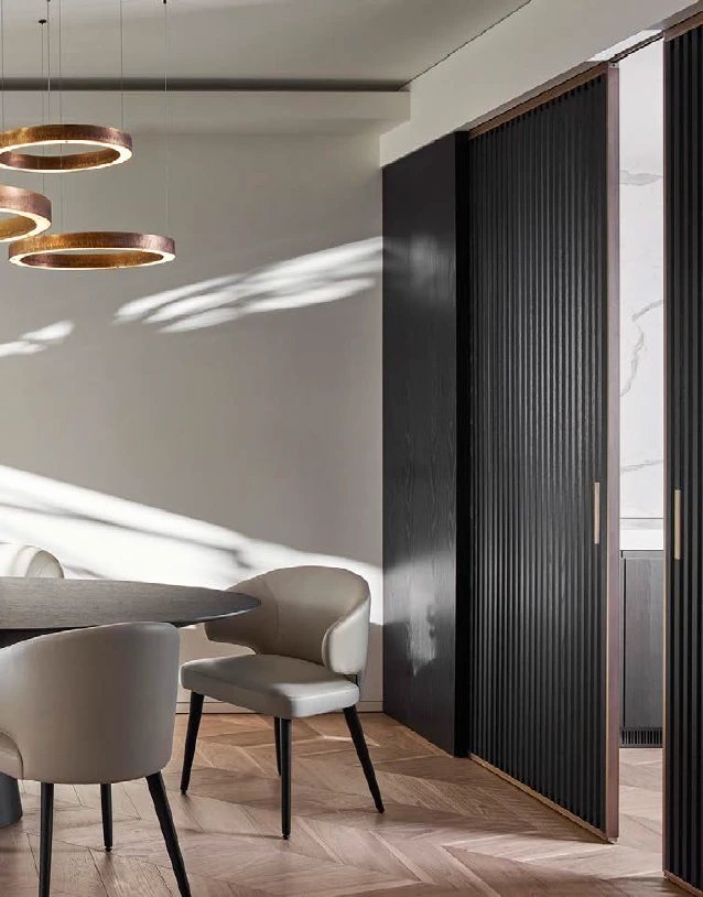 Fluted black sliding doors beside a dining room