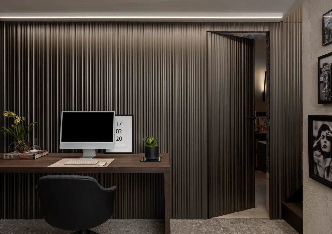 Flush fluted door hidden in a study wall