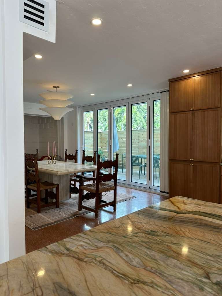 White impact bifold door opening a dining room to the patio