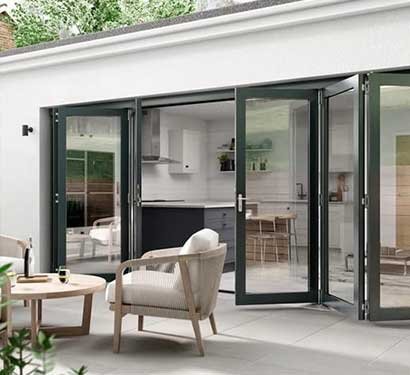 Grey bifold doors folded open from a kitchen to the patio
