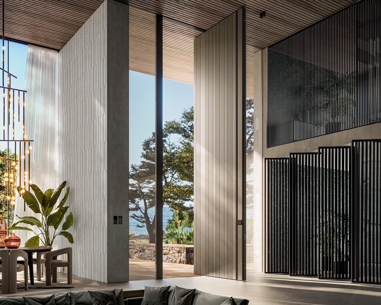 Oversized pivot entry door opening a double-height living room to the sea