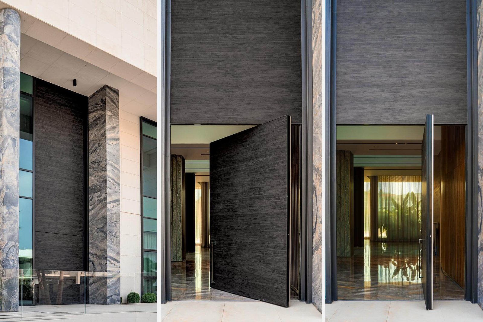 Monumental textured-black pivot entry door between marble columns
