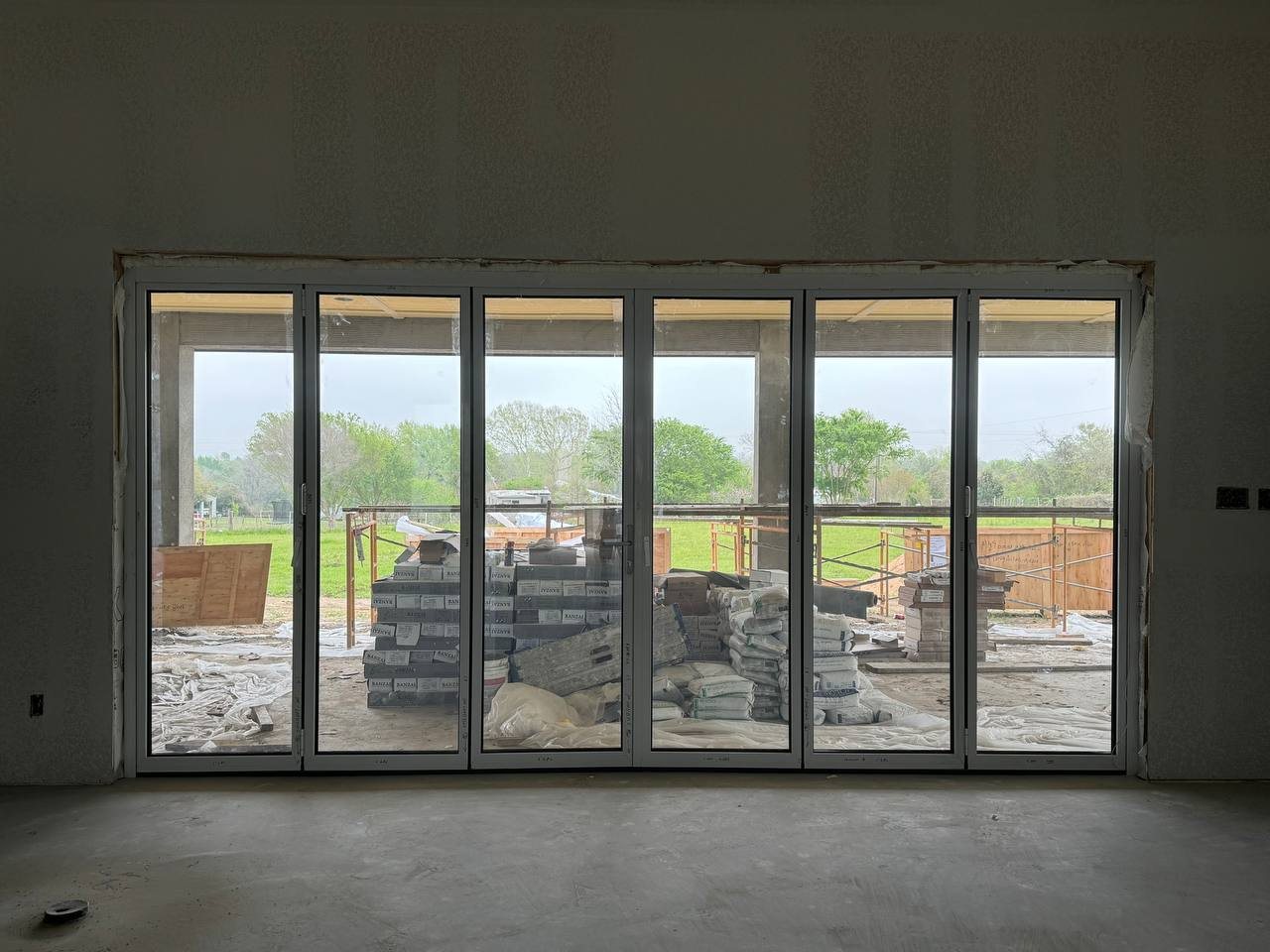 Six-panel white bifold door looking out to the pasture