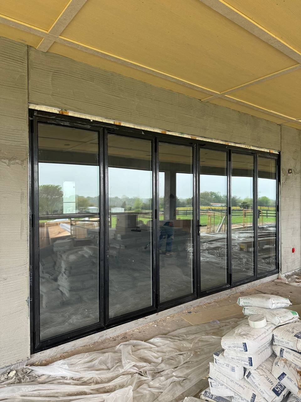 Six-panel black bifold door on a ranch house porch