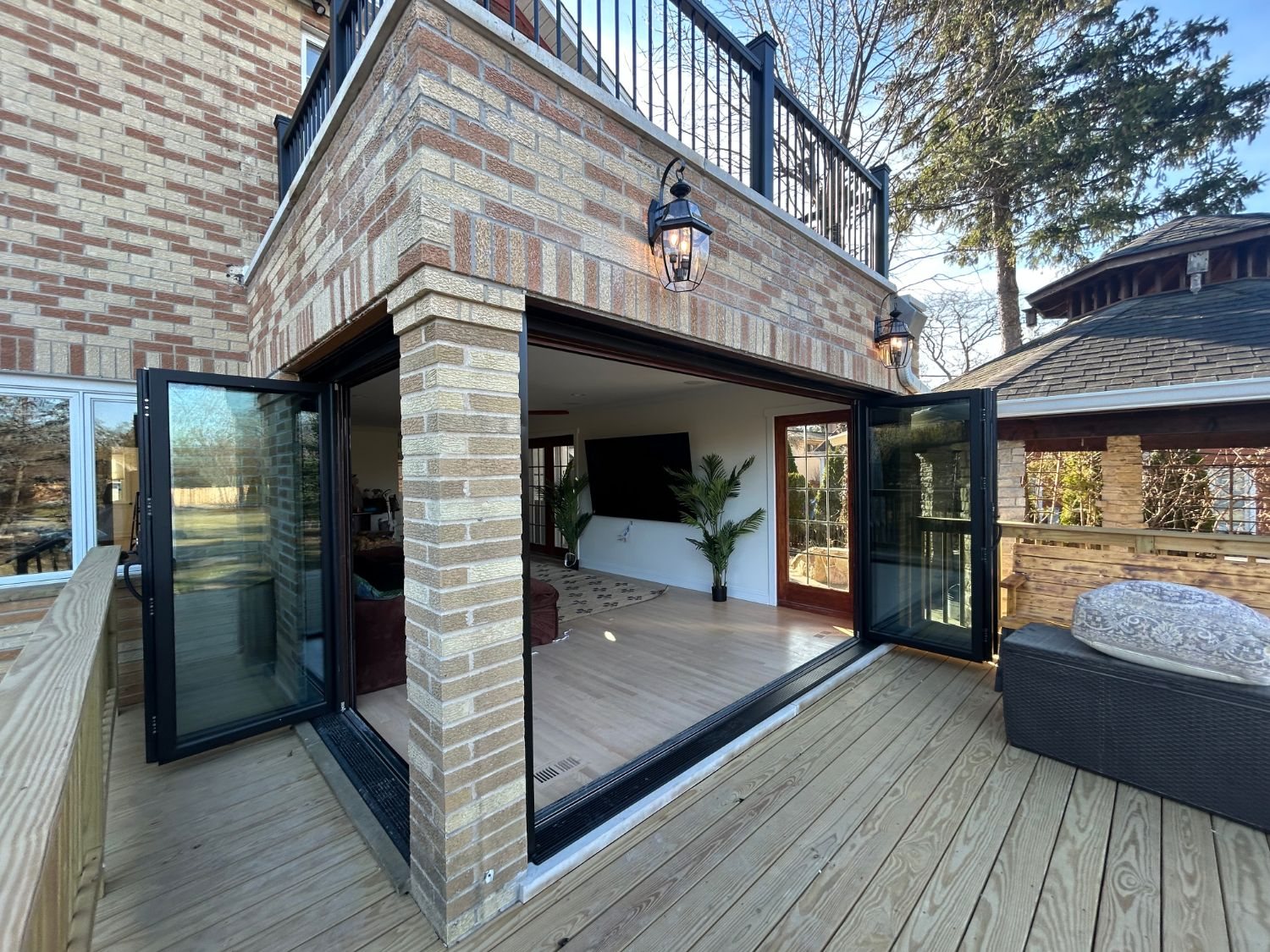 Corner bifold doors folded open to a brick family room