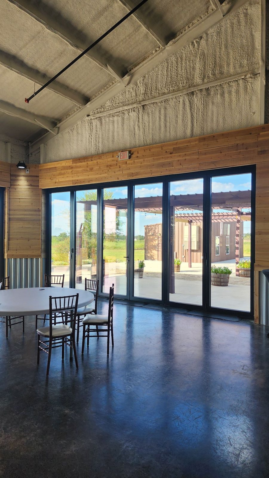 Black bifold door wall in a cedar-paneled event hall