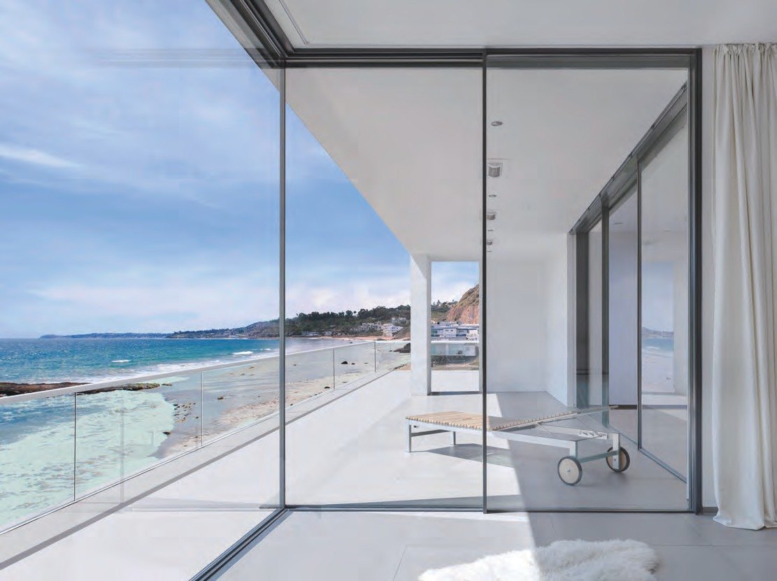 Frameless-look corner sliding doors open to the beach