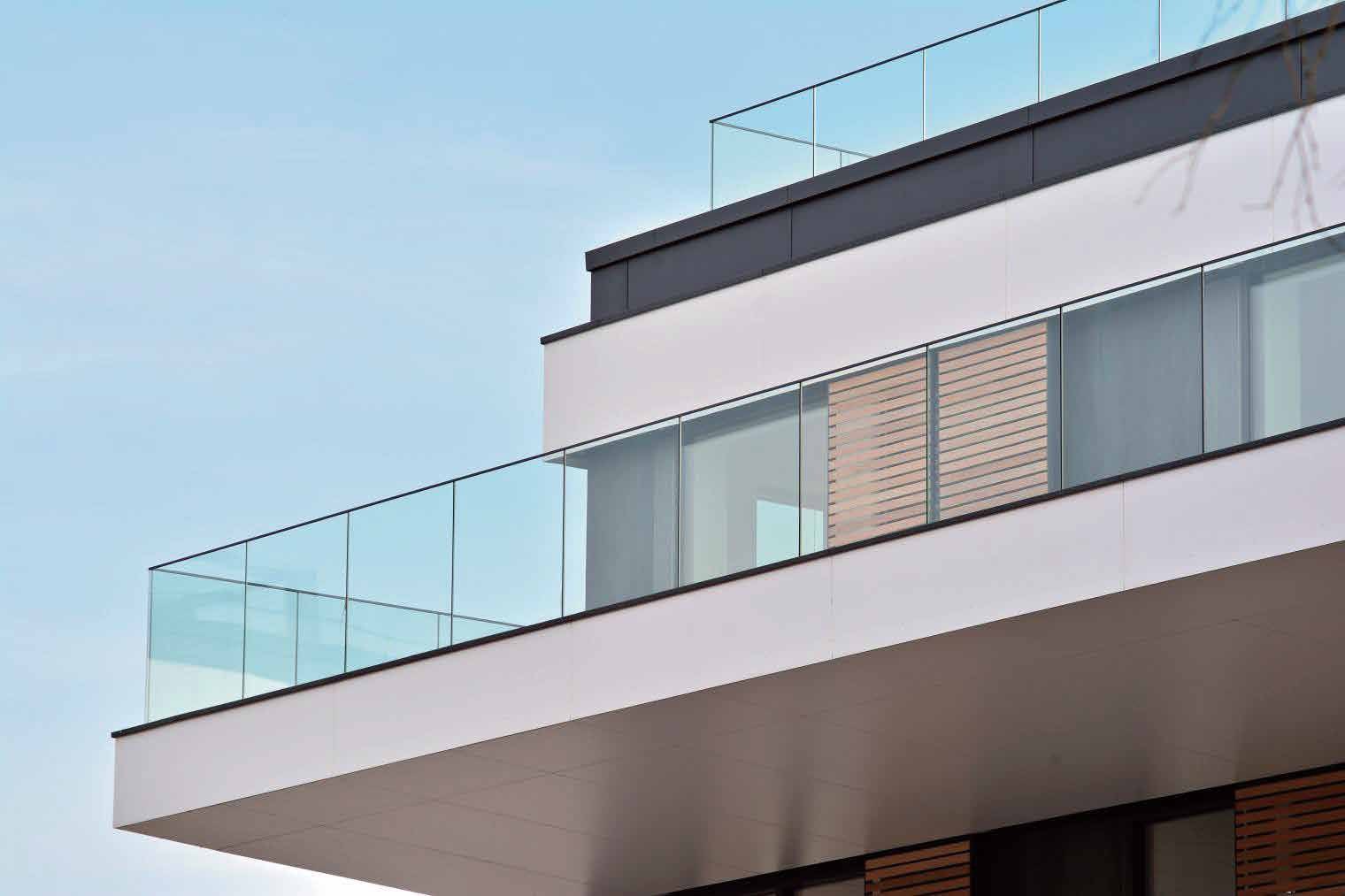 Frameless glass balcony railing on a white villa