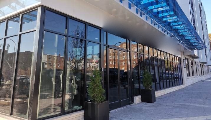 Black aluminum storefront and entrance doors wrapping a street corner