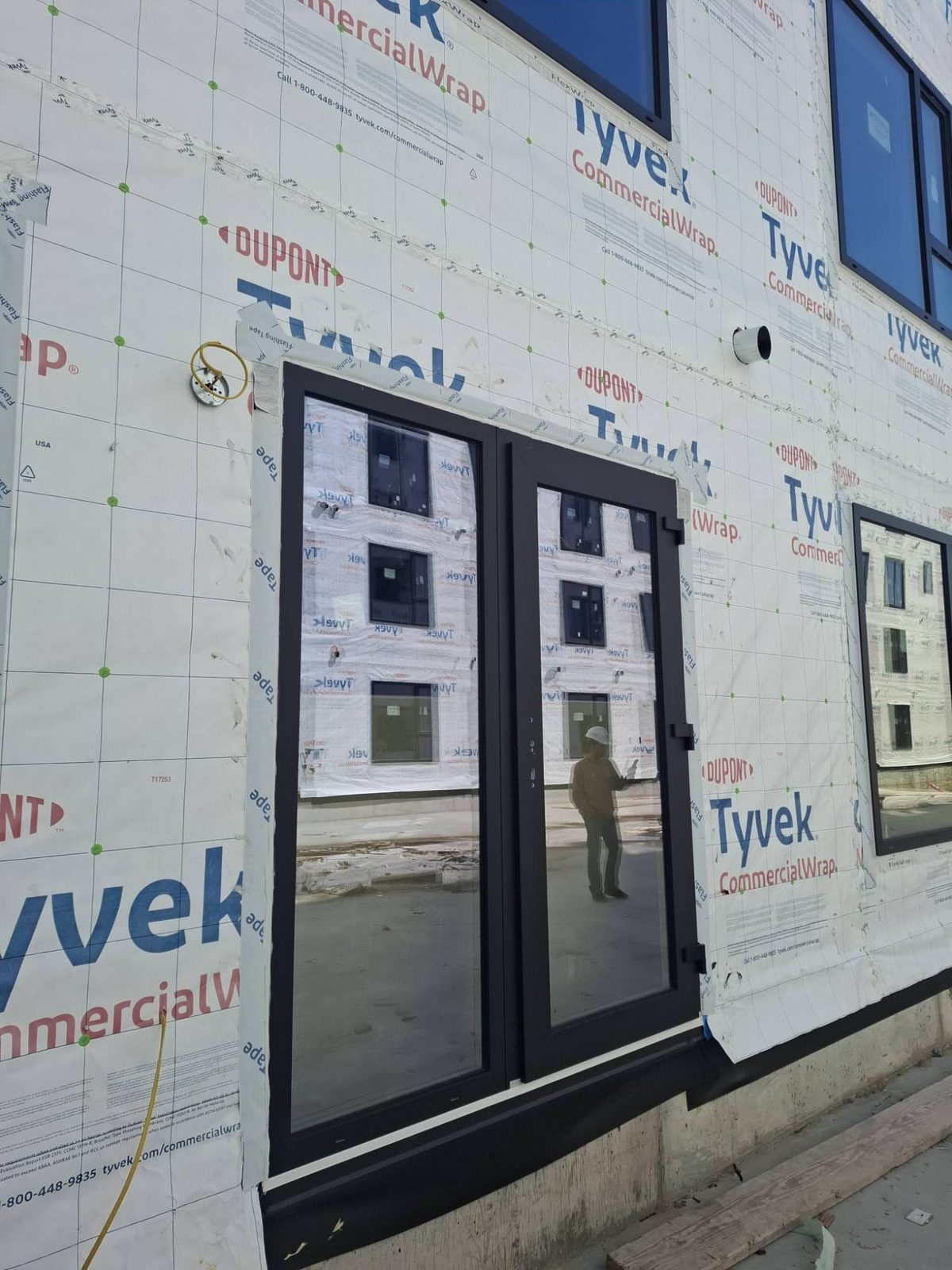 Black aluminum French doors installed in a multifamily building envelope