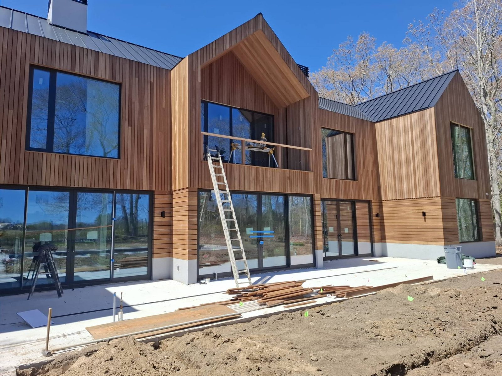 Cedar-clad modern home with black uPVC window walls and sliding doors