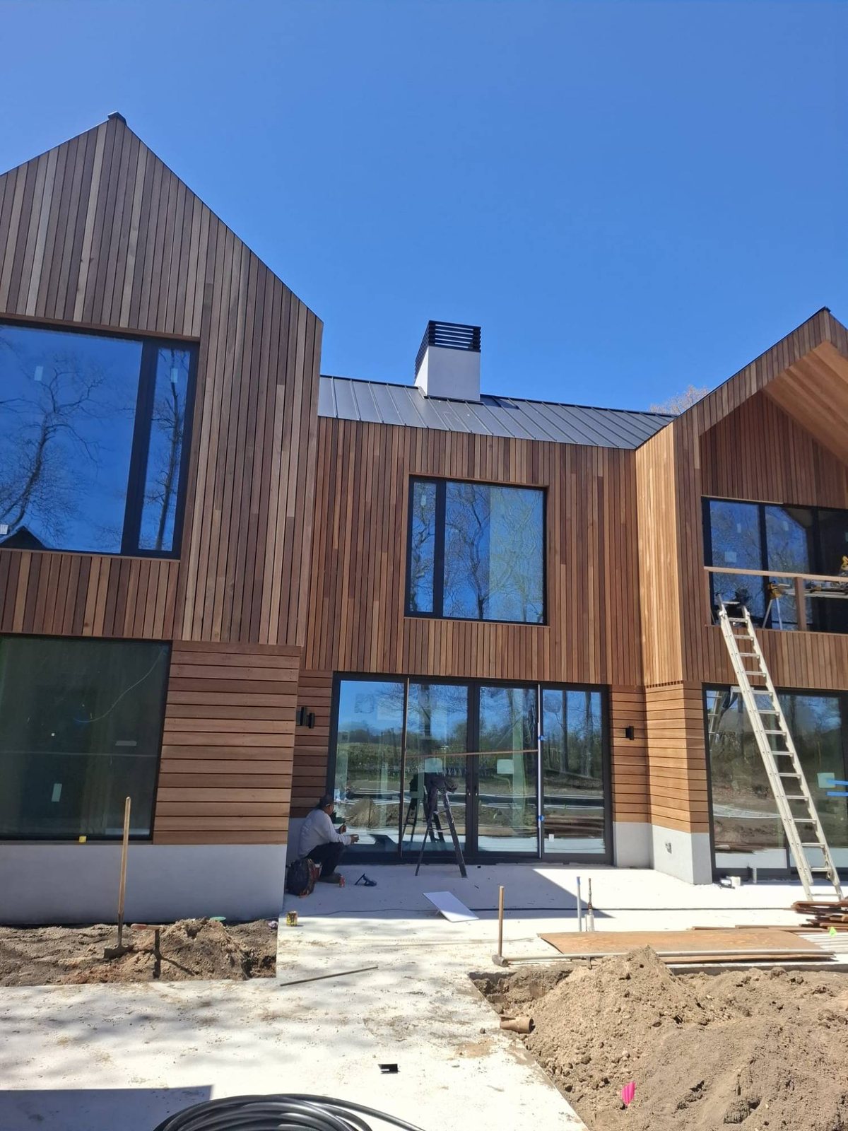 Black uPVC picture windows set into a cedar gable