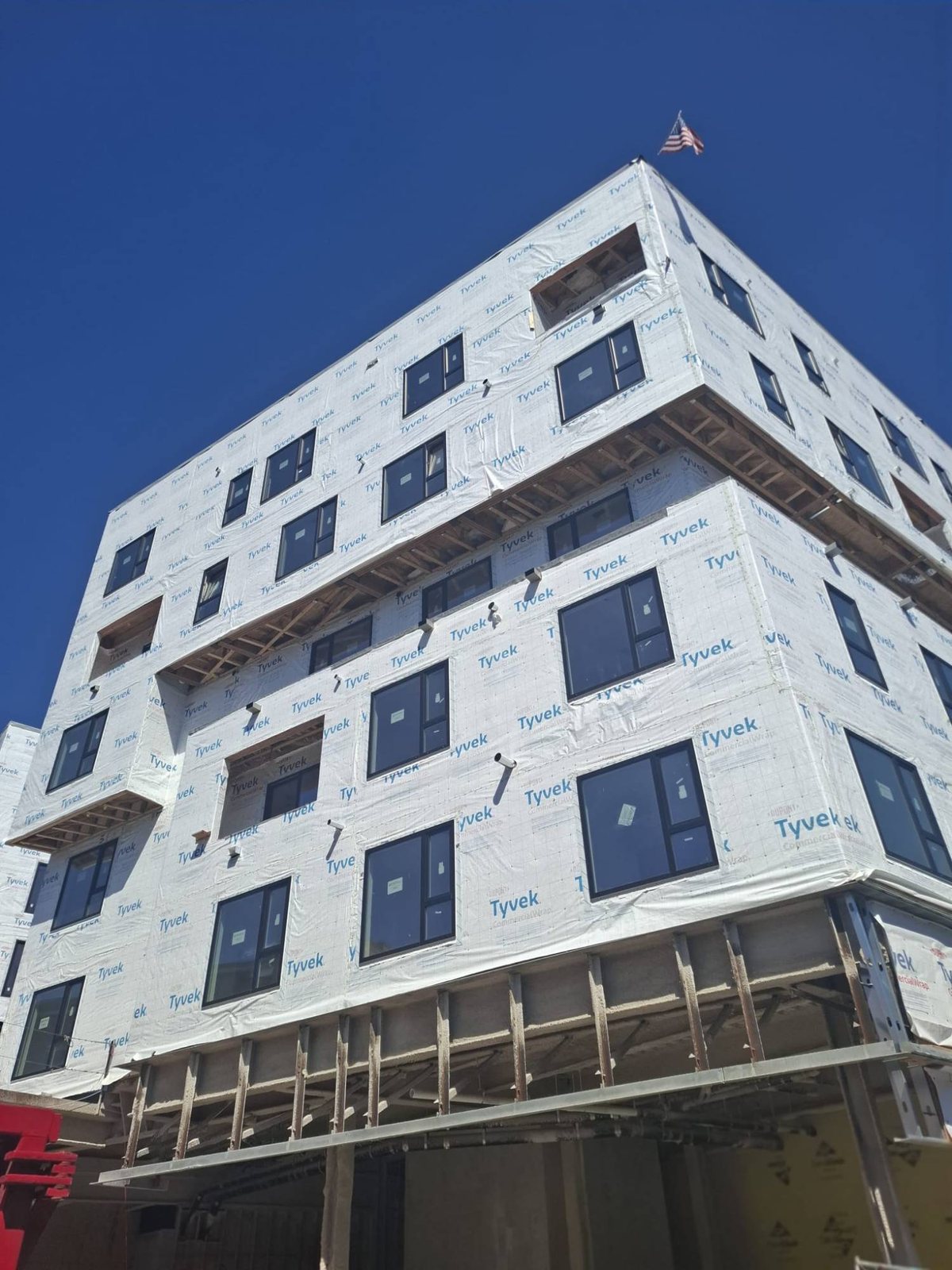 Corner of a multifamily building with stacked black uPVC windows