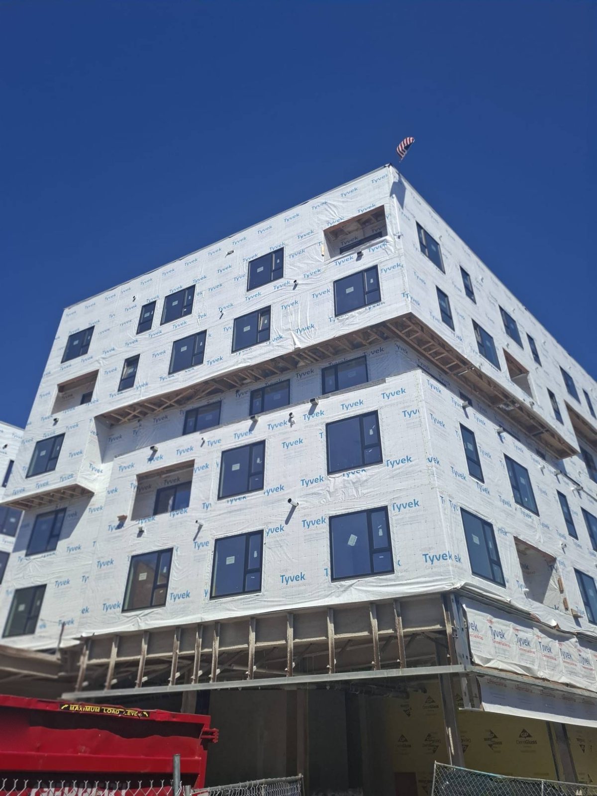 Black uPVC windows across a multifamily facade before cladding