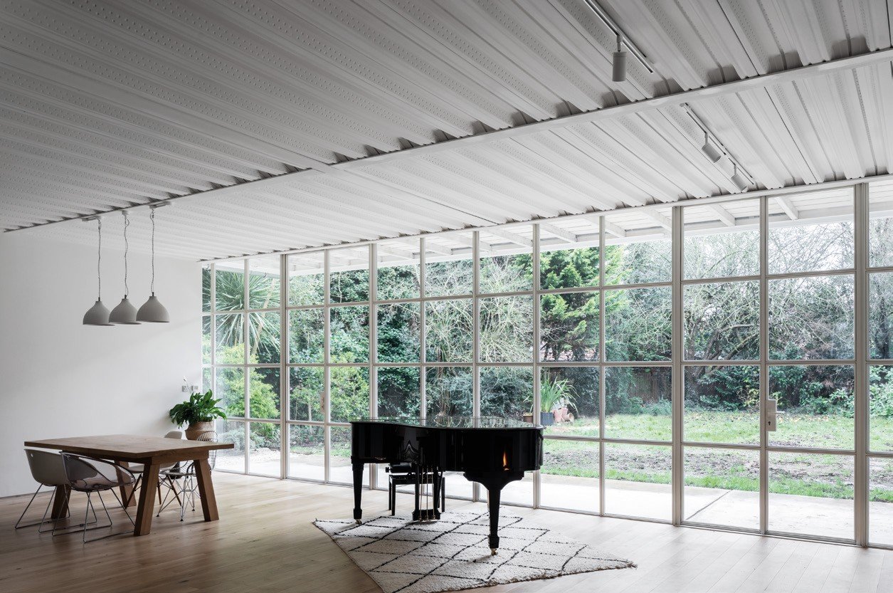 Steel-framed window wall along a light-filled music room