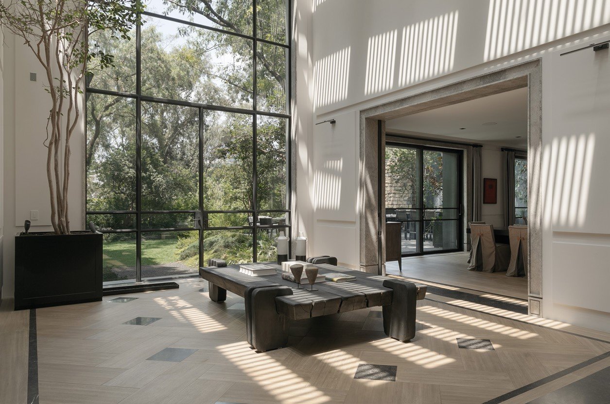 Double-height steel window wall over a living room
