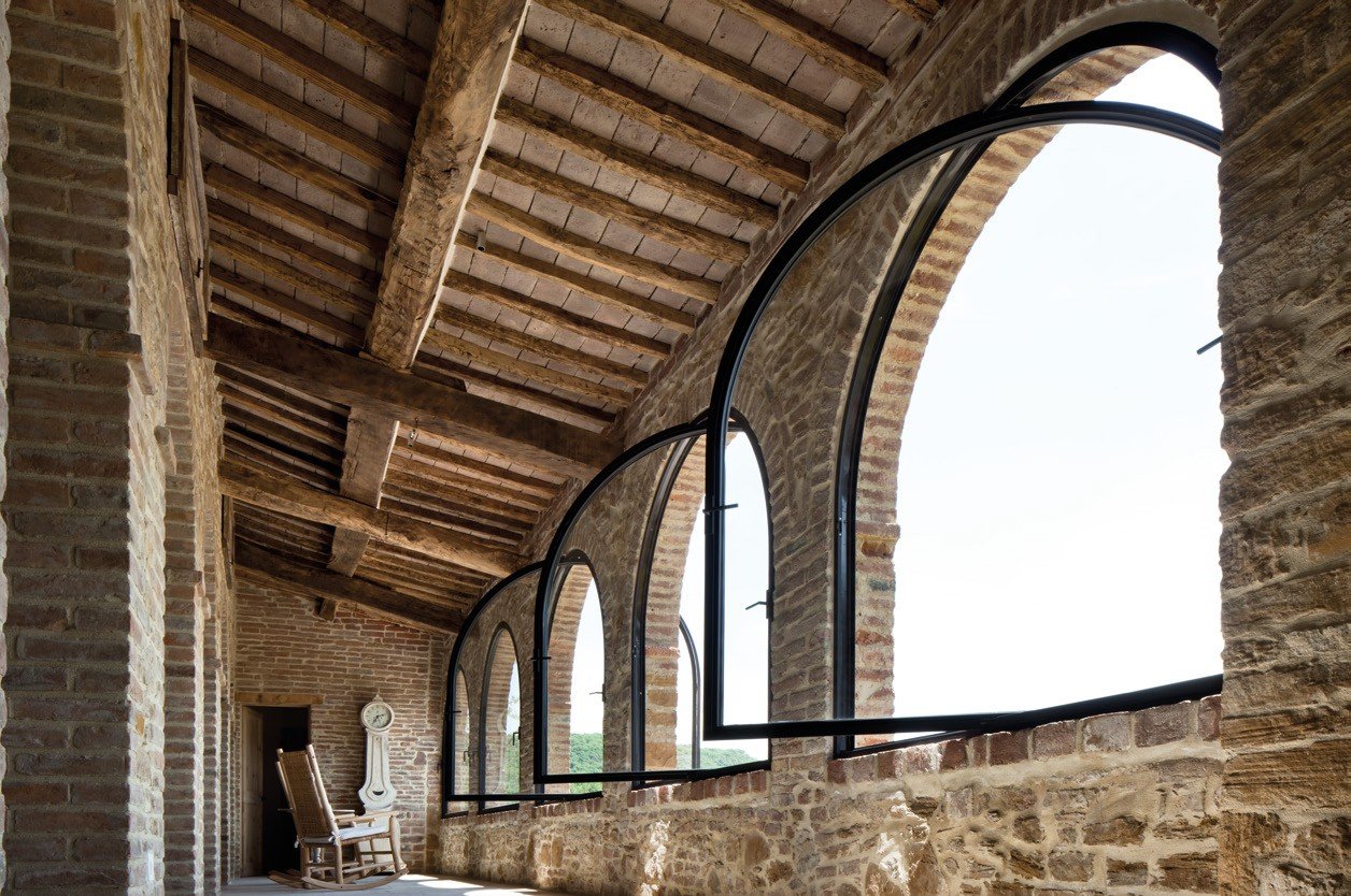 Arched steel windows in a restored stone loft