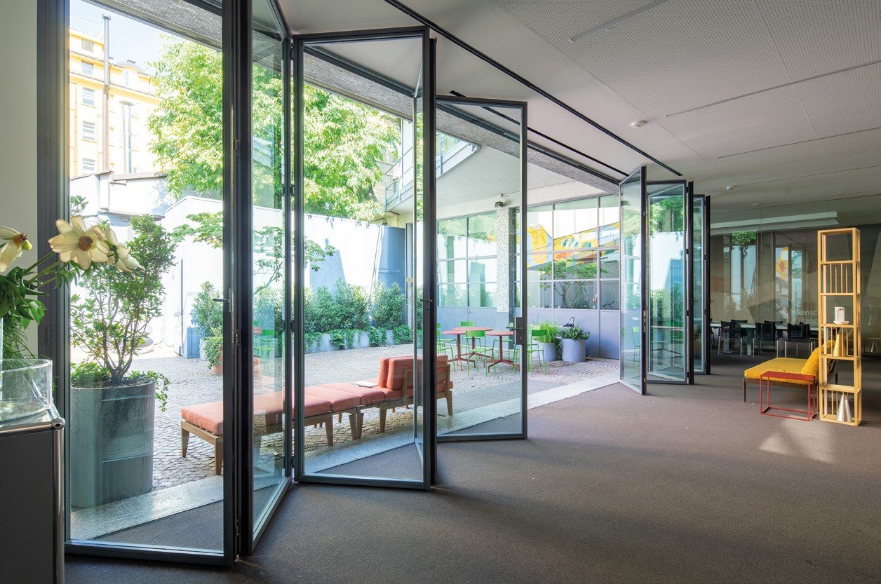 Steel pivot doors opening a city apartment to the terrace