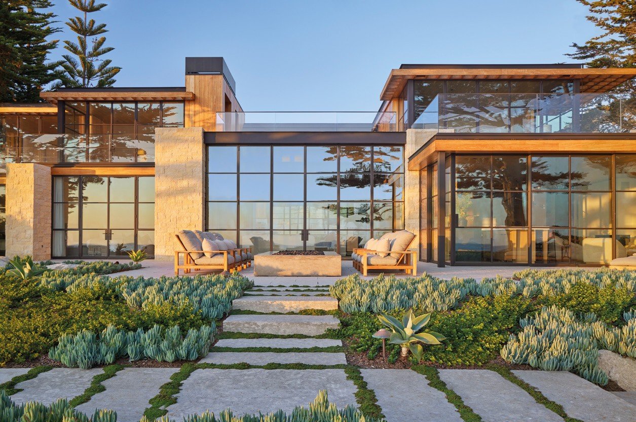 Villa with bronze steel window walls opening to the garden