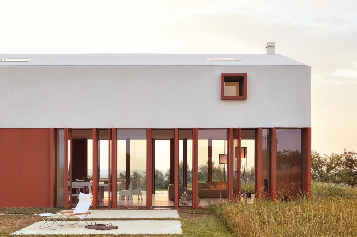 Red steel sliding doors along a country house