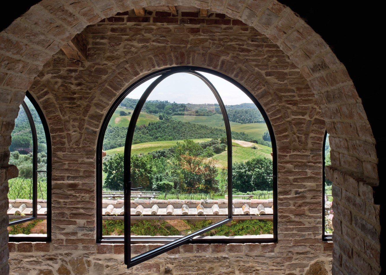 Arched steel pivot window over vineyard hills