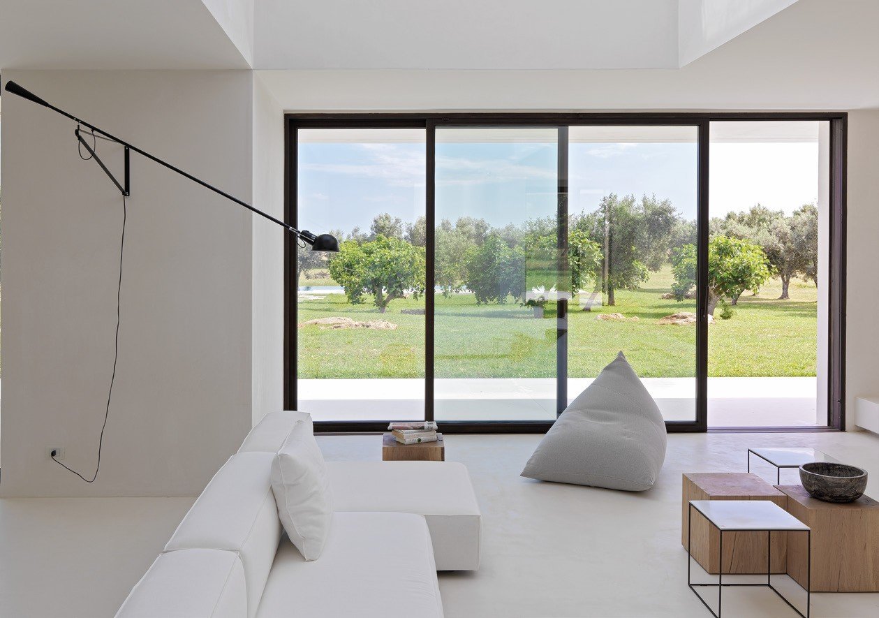 Black steel sliding glass wall onto an olive grove
