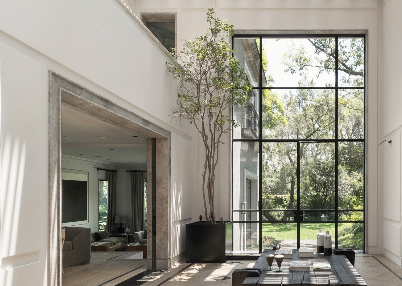 Steel-framed glass door into a two-storey living room