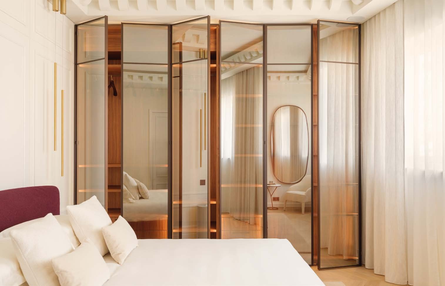 Bronze-framed glass partitions around a bedroom suite