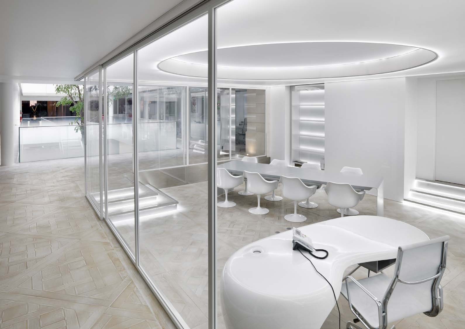 Frameless glass walls around a white meeting room