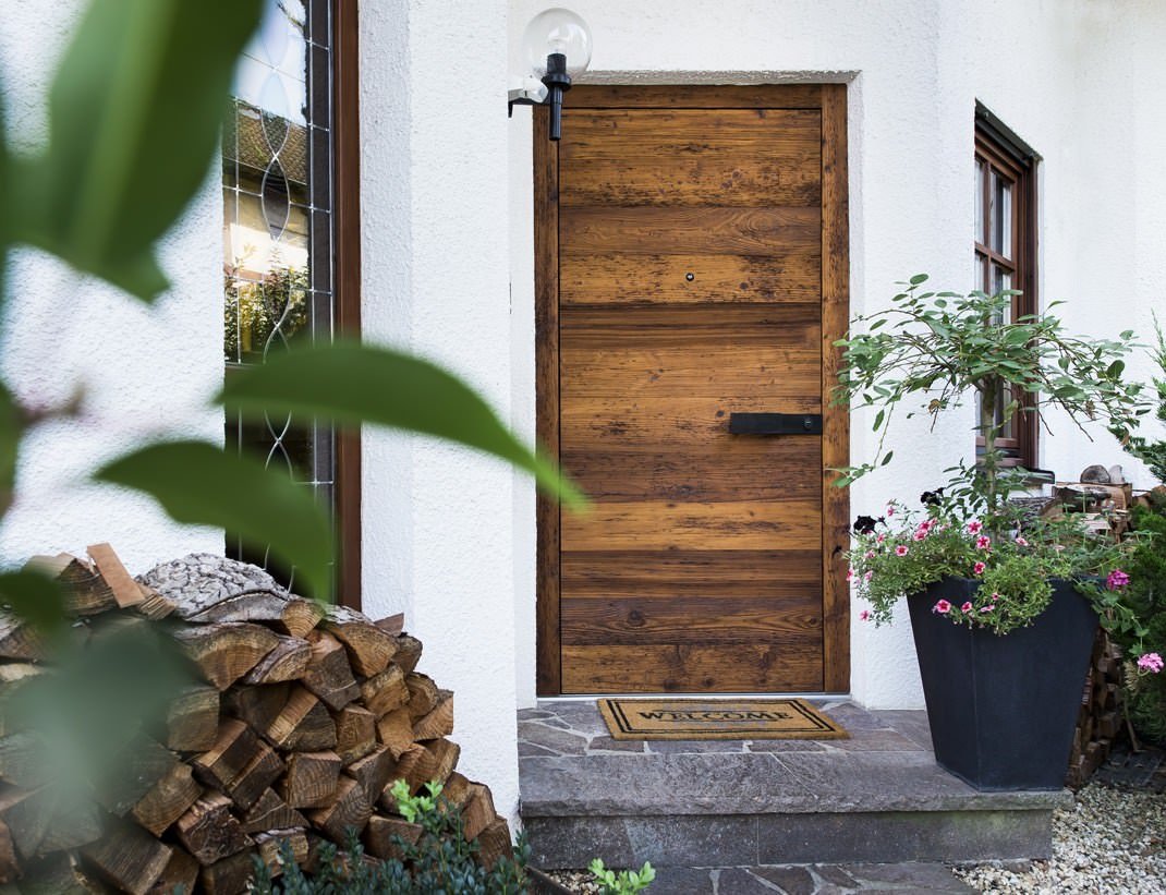 Reclaimed-timber entry door on a whitewashed house